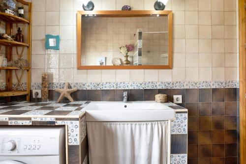 ein Bad mit einem Waschbecken und einem Spiegel in der Unterkunft Casa Nazaret in Conil de la Frontera