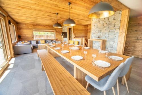 une salle à manger avec une grande table et des chaises en bois dans l'établissement Chalet 14p vue lac, spa et sauna, à Gérardmer