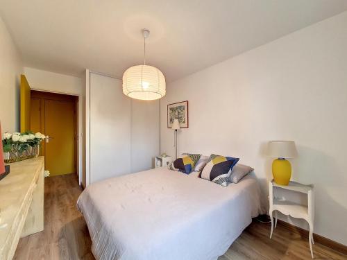 a bedroom with a white bed and a lamp at ღ Le Patio Castanet • T3 avec Terrasse ღ Avec climatisation in Castanet-Tolosan
