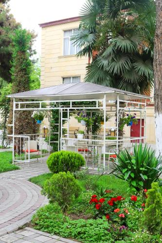 a pavilion with a table and chairs in a garden at Deluxe Hotel Ganja in Ganja