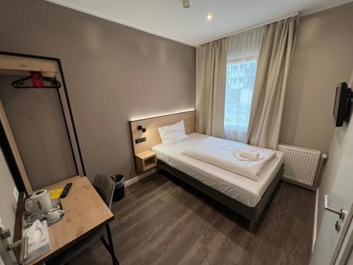 niewielka sypialnia z łóżkiem i oknem w obiekcie JJ Hotel Hannover-City-Pension w Hanowerze