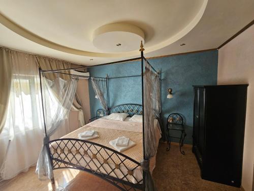 エフォリエ・ノルドにあるPensiunea Diamondの青い壁のベッドルーム1室(天蓋付きベッド1台付)