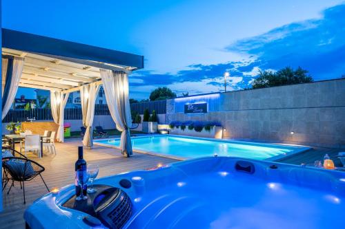 een hot tub op een terras naast een zwembad bij Villa Beauty with heated pool and jacuzzi in Kanfanar