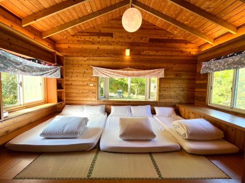 1 dormitorio con 2 camas en una cabaña de madera en Wen Qiao Villa, en Nanzhuang