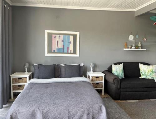 - une chambre avec un lit et un canapé dans l'établissement Casual, beachy and 100m to Seals Surf Spot, à Cape St Francis
