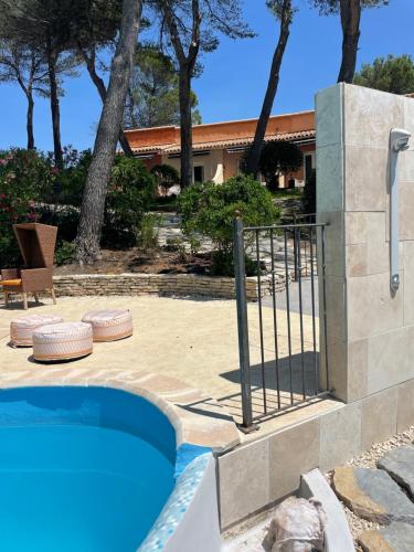 a swimming pool with a fence next to a house at Hôtel La Pinède in Saint-Marcellin-lès-Vaison