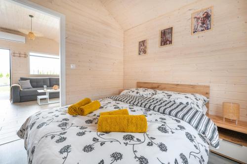 a bedroom with a bed with yellow towels on it at Domki Hulaj Dusza in Bobolin