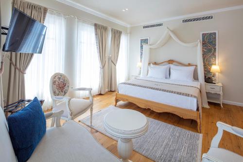 a hotel room with a large bed and a living room at Rasim Palas - Adults Only in Cesme
