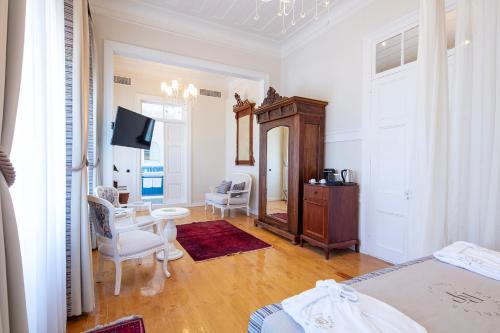 a bedroom with a bed and a desk and a tv at Rasim Palas - Adults Only in Cesme