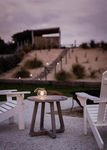a tea kettle sitting on a table next to two benches at Shack In The Dunes in Weymouth