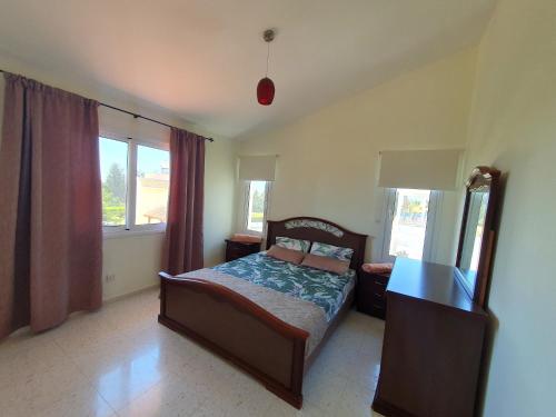 um quarto com uma cama, uma secretária e janelas em Villa Victoria 400 meters to the beach em Pegeia ou Pegya
