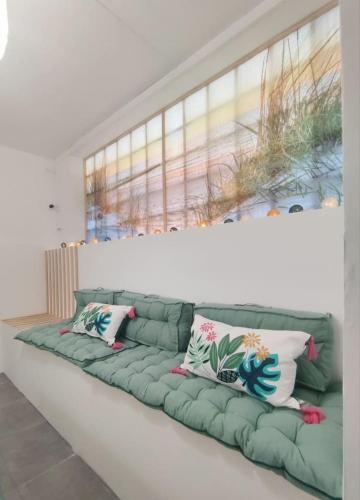 - un canapé vert avec des oreillers dans l'établissement Da Vinci - Charmant et Relax, à Amboise