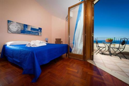 a bedroom with a blue bed and a table at Villa Stefania in Castellammare del Golfo