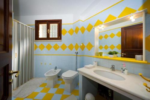 y baño con aseo y lavamanos. en Villa Stefania, en Castellammare del Golfo