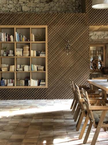a room with a book shelf and a table and chairs at Maison Drôles d'Oiseaux in Plieux