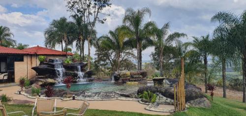una piscina con cascada en un patio trasero en Pousada Mirante do Cerrado en Delfinópolis