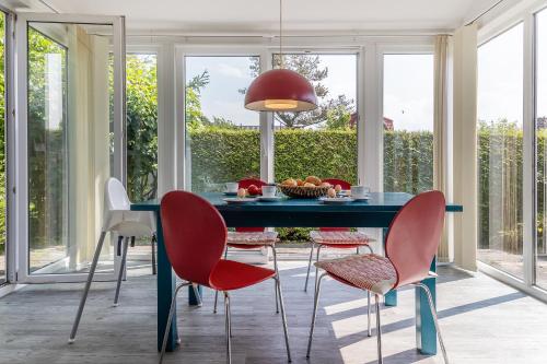 comedor con mesa azul y sillas rojas en 50171 Haus Antje I, en Harlesiel