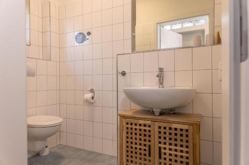 La salle de bains est pourvue d'un lavabo et de toilettes. dans l'établissement 50172 Haus Antje II, à Harlesiel