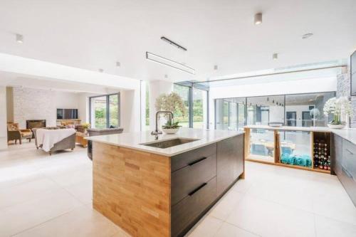 a kitchen with a sink and a living room at Luxury 8 bedroom home with leisure wing in Boars Hill