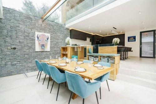 a dining room with a wooden table and blue chairs at Luxury 8 bedroom home with leisure wing in Boars Hill