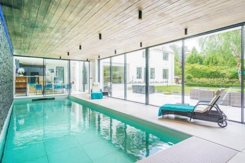 a swimming pool with a chair in a house at Luxury 8 bedroom home with leisure wing in Boars Hill