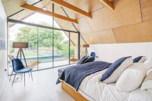um quarto com uma cama e uma grande janela em Luxury 8 bedroom home with leisure wing em Boars Hill