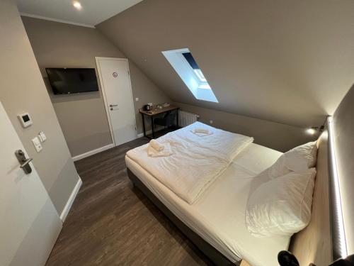 a bedroom with a large white bed with a skylight at JJ Hotel Hannover-City-Pension in Hannover