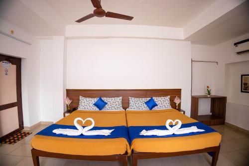 a bedroom with a bed with two swans on it at VKG Hotels in Puducherry