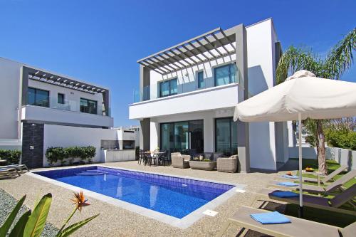 a villa with a swimming pool and a house at Villa Megan in Protaras