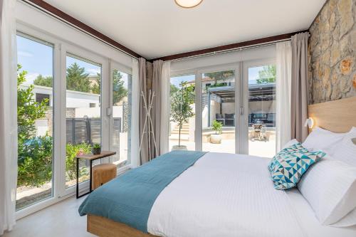ein Schlafzimmer mit einem großen Bett und großen Fenstern in der Unterkunft Kuća za odmor Villa Seahorse in Pinezici