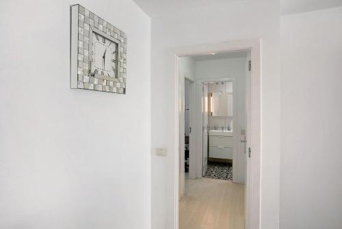a white hallway with a clock on a wall at Medano Beach Home Ocean View in El Médano