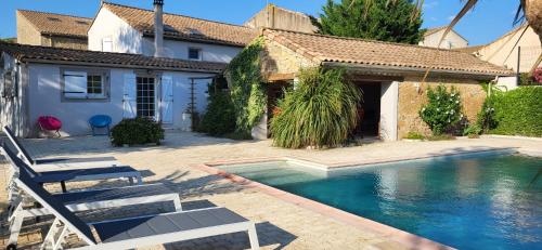 a house with a swimming pool in front of a house at Domaine De L'aube Des Temps in Raissac-dʼAude