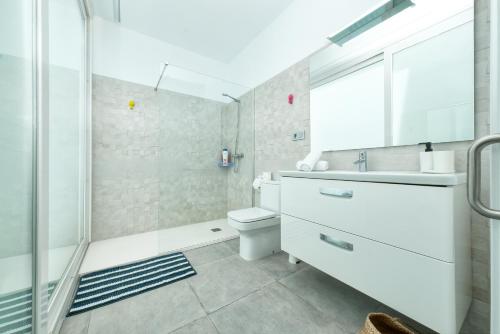 een badkamer met een wastafel, een toilet en een douche bij Karma Famara 2 25m del mar in Famara