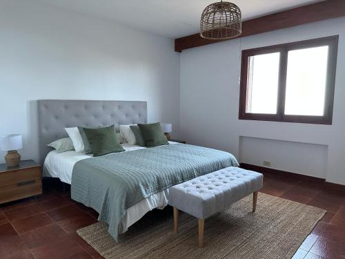 a bedroom with a bed and a window and a bench at Casa Carrillo in Santa Cruz de la Palma