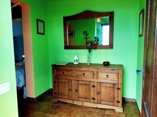 baño verde con tocador de madera y espejo en Las Toscas en Mazo