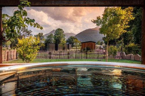 - une vue sur la piscine dans une cour dotée d'une clôture dans l'établissement Pyrénées Prestige - Villas d'exceptions et hébergements insolites, à Argelès-Gazost