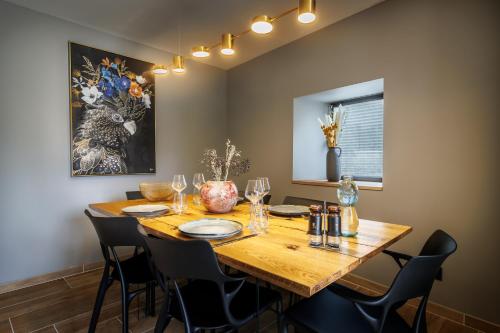 a dining room with a wooden table and chairs at Pyrénées Prestige - Villas d'exceptions et hébergements insolites in Argelès-Gazost