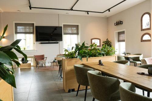 a conference room with a table and chairs and plants at Hofparken Wiltershaar in Kotten