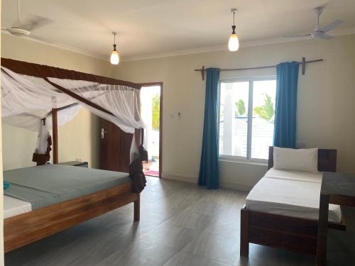 a bedroom with two beds and a window at Summer Beach Paje in Paje