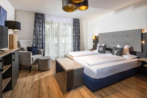 een hotelkamer met 2 bedden en een televisie bij Hubertus Appartements Inzell in Inzell