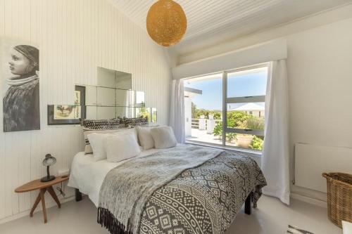 a bedroom with a bed and a large window at Tranquility in Cape St Francis