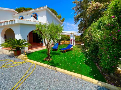 a house with a yard with a hose at Casale fronte mare - villa with swimming pool in front of the beach in Porto Columbu - Perdʼe Sali