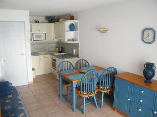 une cuisine avec une table et des chaises dans une cuisine dans l'établissement Coquet Pavillon classé meublé de tourisme Narbonne Plage, à Narbonne-Plage