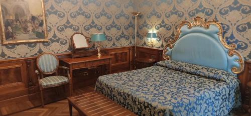 a bedroom with a blue bed and a mirror at Bellevue Luxury Rooms - San Marco Luxury in Venice
