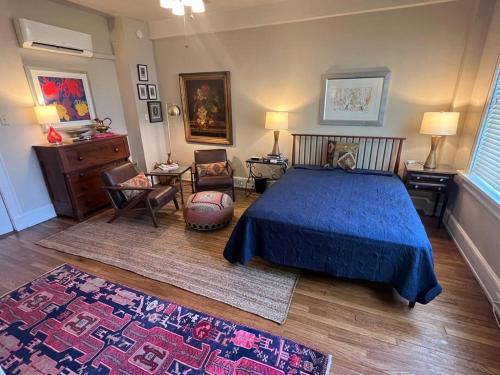 a bedroom with a blue bed and a rug at Cozy Bohemian Midtown Studio at Minglewood Hall in Memphis
