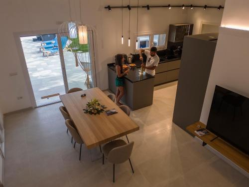 two people standing in a kitchen with a table at Villa Golden Root Real Estate in San Teodoro
