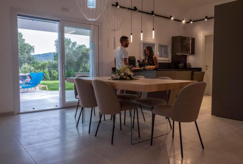 a man and woman in a kitchen with a table and chairs at Villa Golden Root Real Estate in San Teodoro