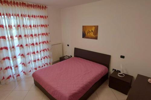 een slaapkamer met een bed met een roze deken bij Casa vacanze Margherita in Barletta