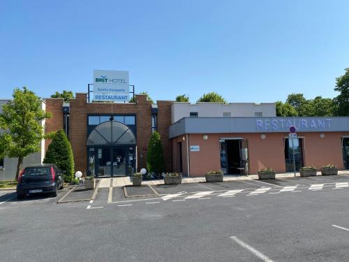 a parking lot in front of a store at Brit Hotel Reims La Pompelle in Reims