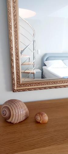 two seashells on the floor in front of a mirror at Al mare in Sounio